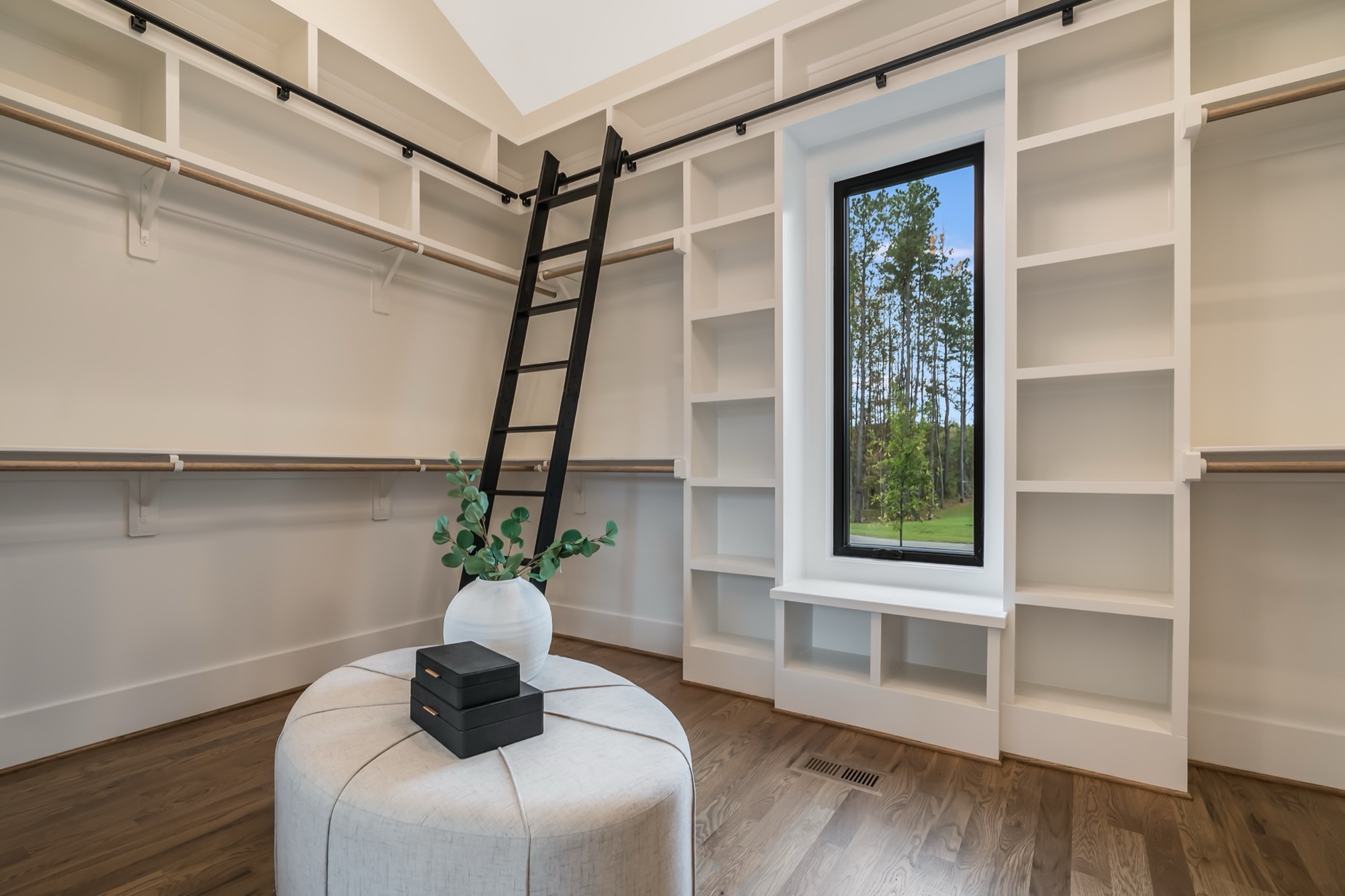 Master closet with rolling library ladder and built-ins