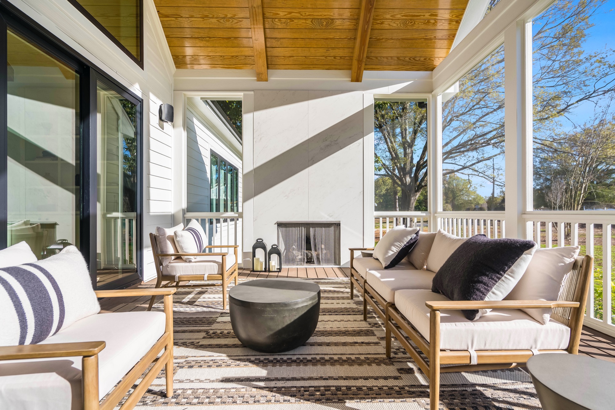 Screened porch with cushioned seating and fireplace